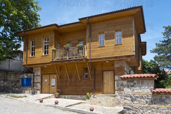 Traditional wooden house on stone foundation on a sunny summer day with blue sky