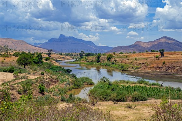 River flowing through rural landscape with distant mountains in the Haute Matsiatra Region