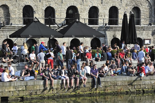 People enjoying the first spring sun by the waterside along the Graslei at Ghent