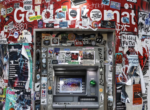 ATM with graffiti and stickers on the RAW site. The RAW site is the former Reichsbahn repair works in the Friedrichshain district. Today