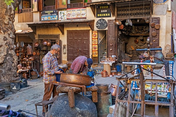 Moroccan coppersmiths working in workshop on Place Seffarine