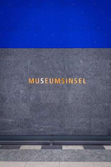 Golden lettering 'Museum Island' on a grey background in a railway station