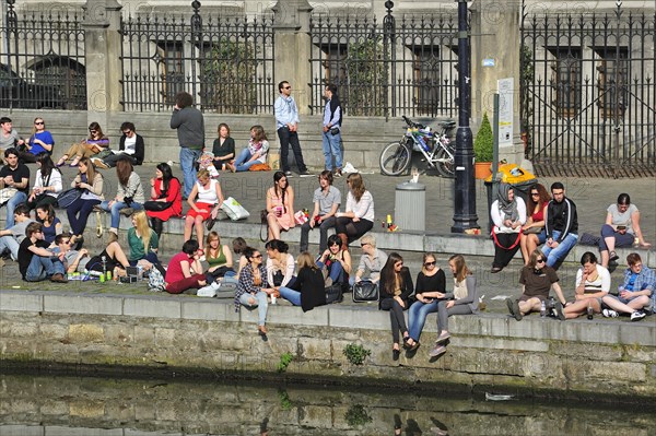 People enjoying the first spring sun by the waterside along the Graslei at Ghent