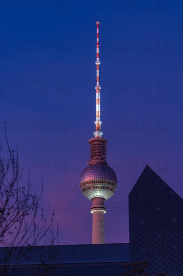 Television tower against the evening sky with illuminated antenna