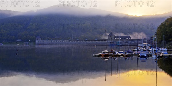 Eder dam with dam wall and pleasure boats on the Edersee in the early morning