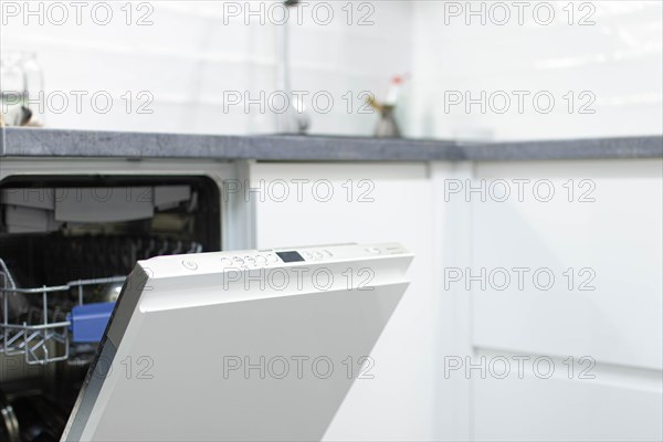 White modern dishwasher in the interior of a white kitchen