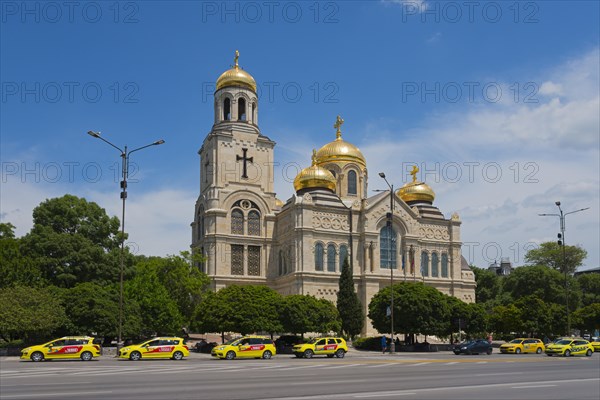 Golden domes of a church stand out under a clear blue sky