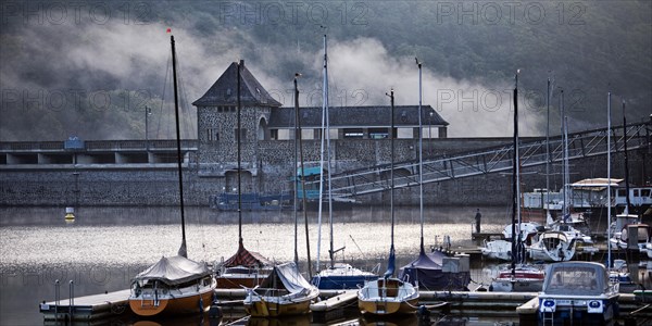 Eder dam with dam wall and pleasure boats on the Edersee in the early morning