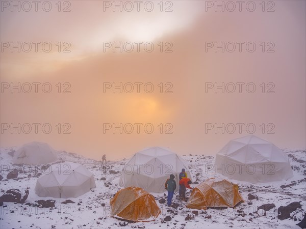 Snow-covered tents in the high camp of Chimborazo