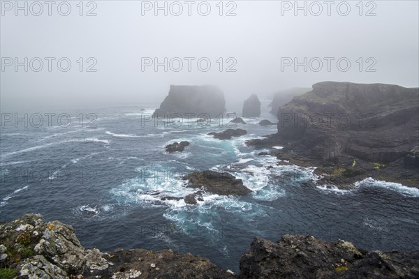 Sea stacks and sea cliffs in mist during stormy weather at Eshaness