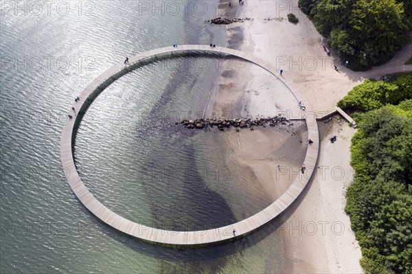 An aerial view shows people walking on the infinite bridge. The bridge is a work of art built by Sculpture by the Sea