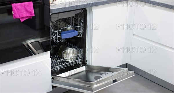 White modern dishwasher in the interior of a white kitchen
