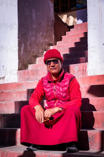 A monk sitting on the stairs to Korzok monastery