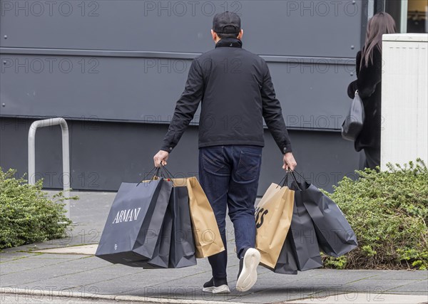 Consumer tourist lugging shopping bags