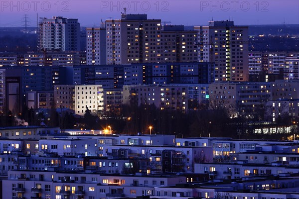 View in the evening at blue hour of high-rise buildings and apartment blocks with rental flats and condominiums in the Berlin district of Marzahn-Hellersdorf