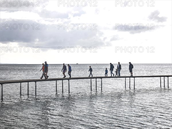 People walking on the infinite bridge . The bridge is a work of art built for Sculpture by the Sea