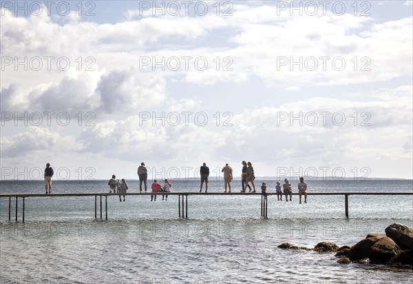 People walking on the infinite bridge . The bridge is a work of art built for Sculpture by the Sea