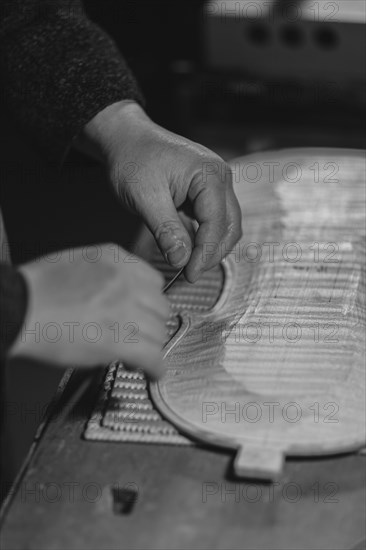 Unrecognizable luthier lute maker artisan hands in his workshop try