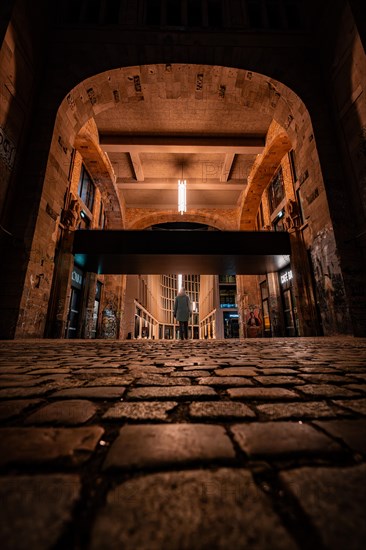 Night view of an illuminated arched brick gate