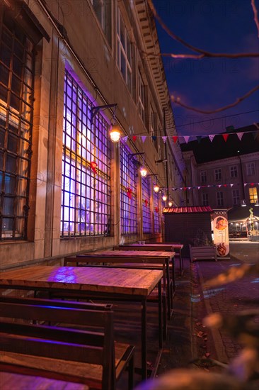 Tables of a street cafe in the evening light and colourful lighting