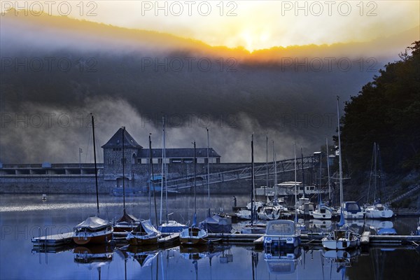 Eder dam with dam wall and pleasure boats on the Edersee in the early morning