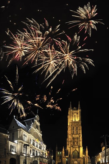 Colourful fireworks above the Saint Bavo's Square with theatre and the Saint Bavo's cathedral at night