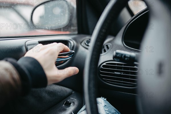 The driver behind the wheel presses the door open button