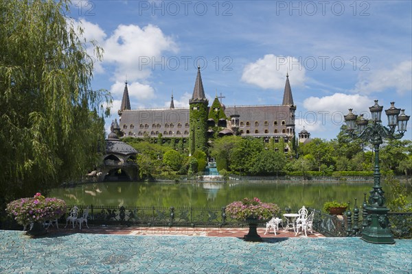 A picturesque castle with turrets is reflected in a tranquil lake