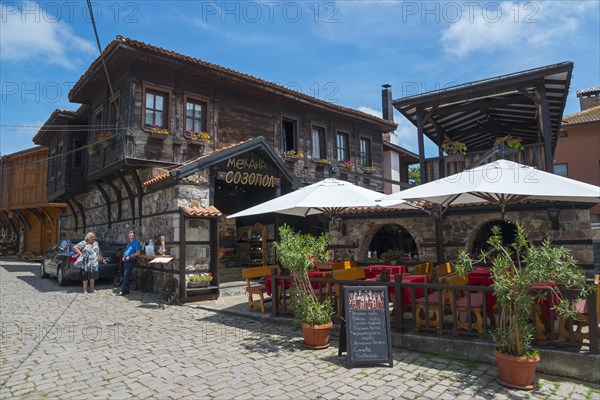Cosy restaurant in an old town with traditional wooden architecture on a sunny day