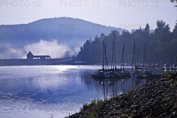 Eder dam with dam wall and pleasure boats on the Edersee in the early morning