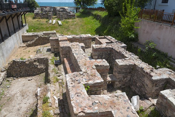 A historical archaeological site overlooking the sea on a sunny day with clear skies