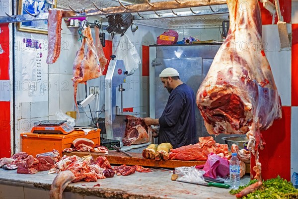 Butcher cutting meat in butcher's shop