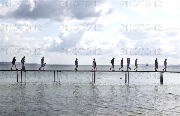 People walking on the infinite bridge . The bridge is a work of art built for Sculpture by the Sea