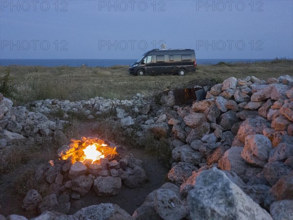 Eternal fire at night with view of motorhome