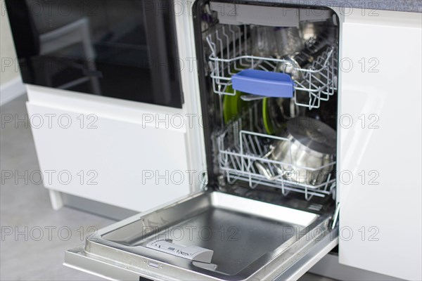 White modern dishwasher in the interior of a white kitchen