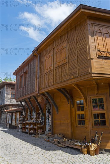 Traditional wooden house with shutters and decorations under a clear blue sky