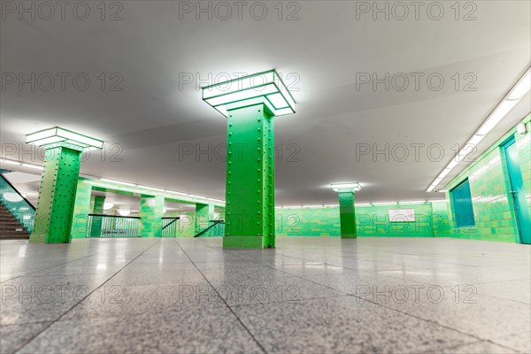 Symmetrically arranged green columns in a modern underground station