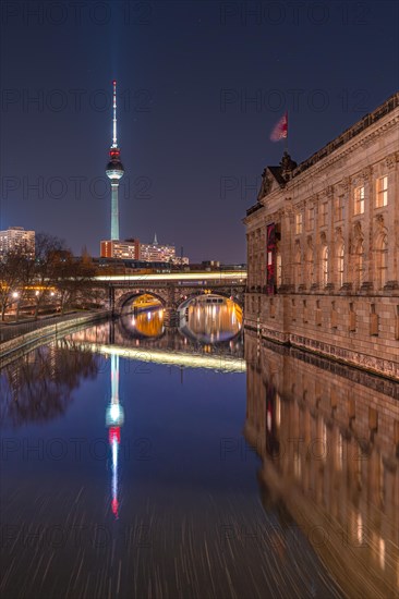 Nocturnal reflection of the television tower and a bridge in the water of a river