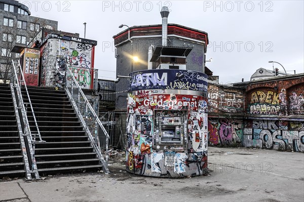 ATM with graffiti and stickers on the RAW site. The RAW site is the former Reichsbahn repair works in the Friedrichshain district. Today