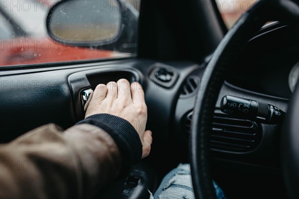 The driver behind the wheel presses the door open button