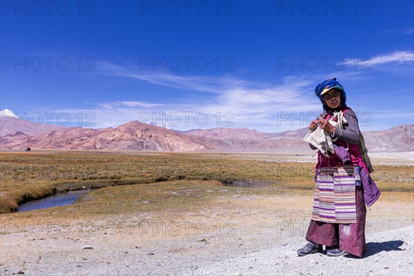 Changpa nomad knitting while watching her goats