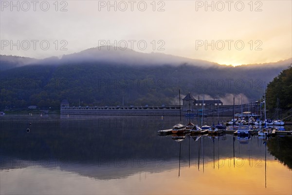 Eder dam with dam wall and pleasure boats on the Edersee in the early morning