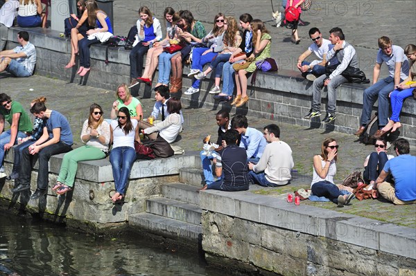 People enjoying the first spring sun by the waterside along the Graslei at Ghent