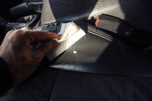 The driver cleans the leather interior of the car