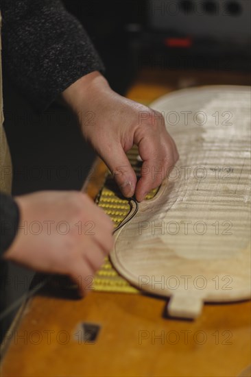 Unrecognizable luthier lute maker artisan hands in his workshop try