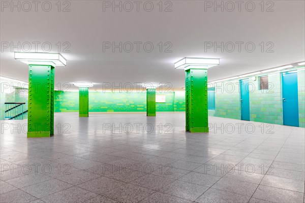 Empty Alexanderplatz underground station with symmetrical architecture and green accents