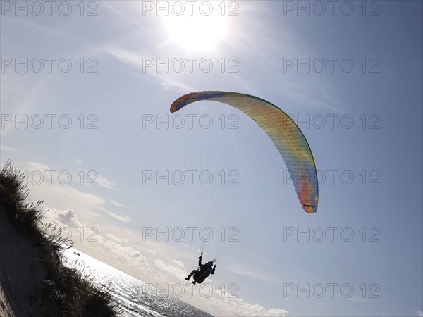 Paragliders flying over a beach at the North Sea