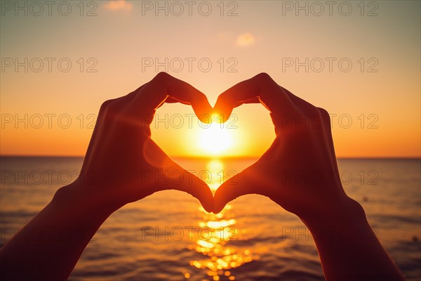 Two hands forming a heart shape, silhouetted against a breathtaking ocean sunset. Love and warmth on Valentine Day or any romantic occasion, AI generated