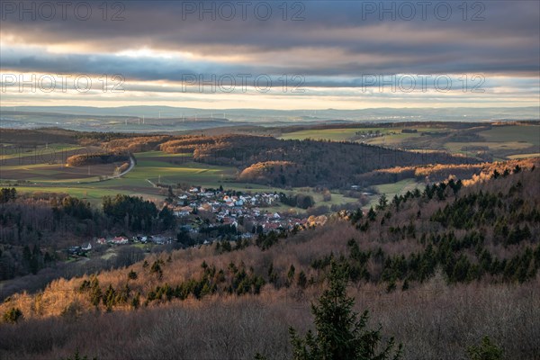 Landscape at the Grosser Zacken, Taunus volcanic region. A cloudy, sunny autumn day, meadows, hills, fields and forests with a view of the sunset. Hesse, Germany, Europe