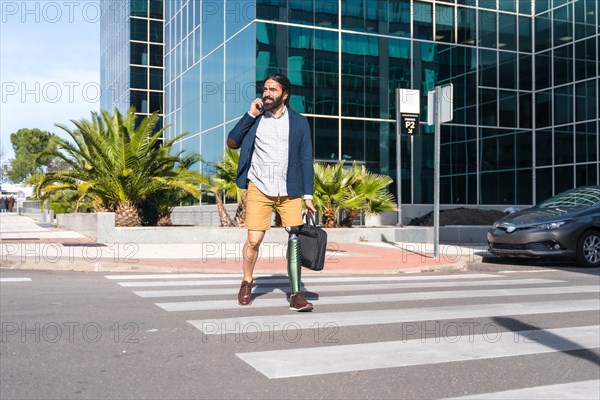 Businessman with amputee leg talking to the mobile while commuting along a financial street